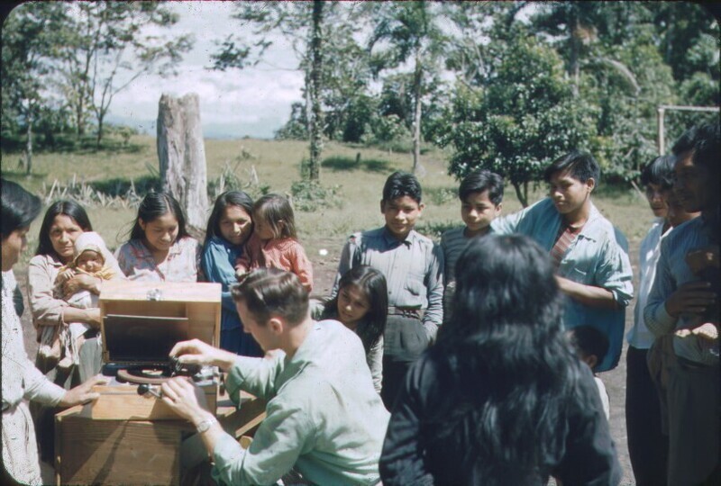 Jim Elliot plays records for his Quichua students, possibly at Puyupungu or Shandia, c. 1954. Color slide, 1x1 in.