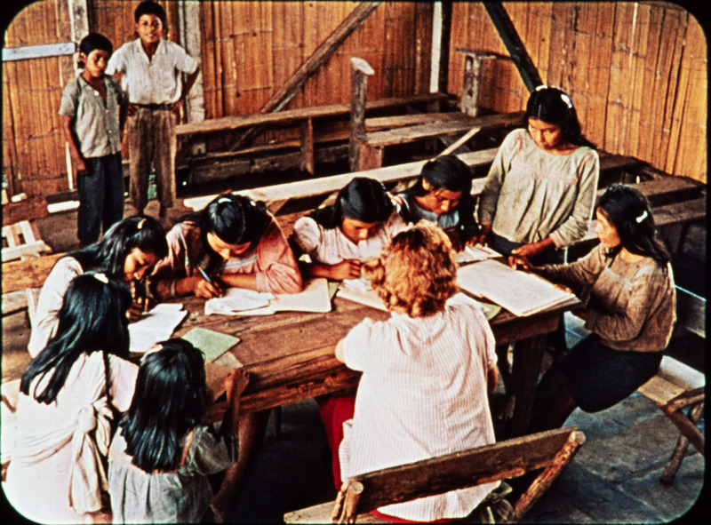 Image of Marilou McCully conducting literacy class with Quichua women at Arajuno. Frame from <i>Mid-Century Martyrs</i> filmstrip developed by HCJB, Mission Aviation Fellowship, and the five widows in 1956.