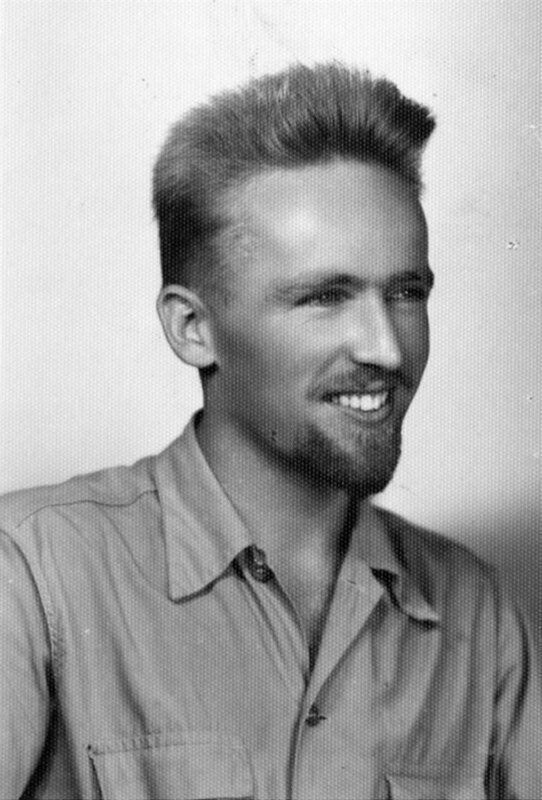 Photograph of Nate Saint with beard sent along with his application to Wheaton College. Handwritten on the back of the photo: “The beard was ‘made in Mexico' and will not be brought to Wheaton, if I’m fortunate as to be accepted.” Black and white photograph, 3-1/2” x 2-1/4”.