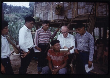 Color slide of V. Raymond Edman with five Waorani men during visit to Tewæno for Bible Confrence in September 1965. Geuquita (Gikita) is seated below Edman, the other men are unidentified.