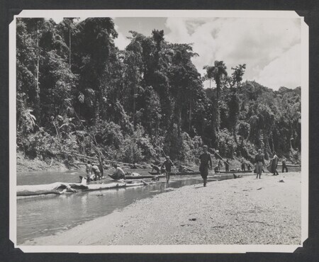 Team of Ecuadorian soldiers, Quichua Indians, and missionaries conduct ground search for missionaries by canoe down Curaray River. Original USCARIB Central caption reads: "Ground party personnel, consisting of Ecuadorian soldiers, American missionaries, and friendly Indians, search along the banks of the Curaray River in the upper Amazon basin of Ecuador for the bodies of the five American missionaries murdered by savage Auca Indians. Four of the bodies were subsequently recovered and buried in a common grave beneath the tree house they had constructed alongside the sandy beach where they were murdered."