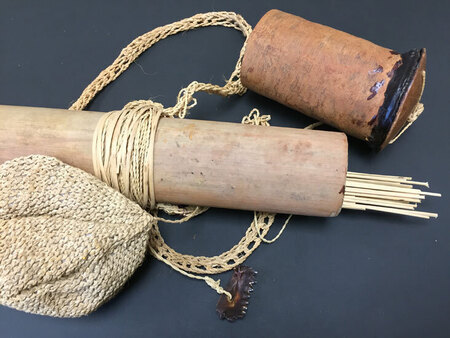 Waorani hunting artifacts, including darts and quiver, woven bag, and piranha teeth. The woven bag was used to hold kapok that was twirled on a dart to give resistance to blow against. The piranha teeth were used to score the dart to keep it from falling out after hitting a hunted animal. Part of a small collection of Waorani artifacts that Rachel Saint gave to the Billy Graham Center Museum in 1984, which were transferred to Wheaton Archives & Special Collections in 2015.