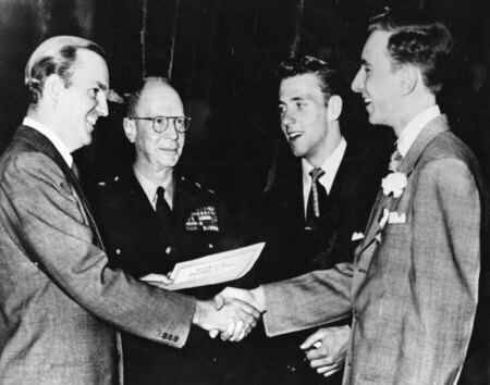 Photo of Ed McCully (second from right) receiving prize. Discovering his oratorical talent in high school, McCully received several prizes in oratorical competitions. 